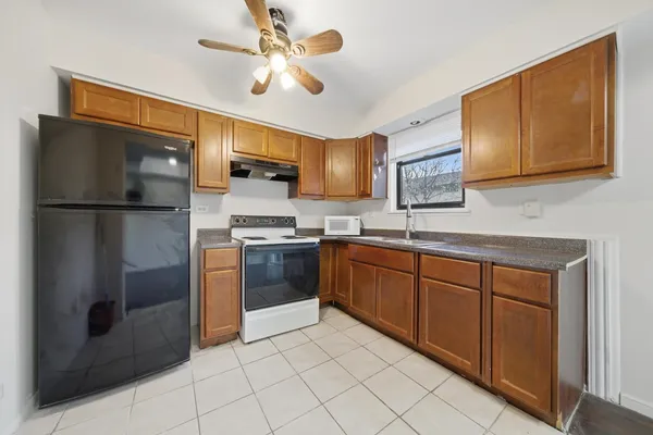 a kitchen with stainless steel appliances granite countertop a refrigerator a sink dishwasher a stove with wooden cabinets