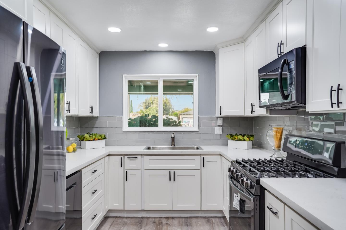 460 Dixon Road Milpitas, CA 95035 - Photo 8 of 36 a kitchen with stainless steel appliances white cabinets a stove a sink a refrigerator and a window