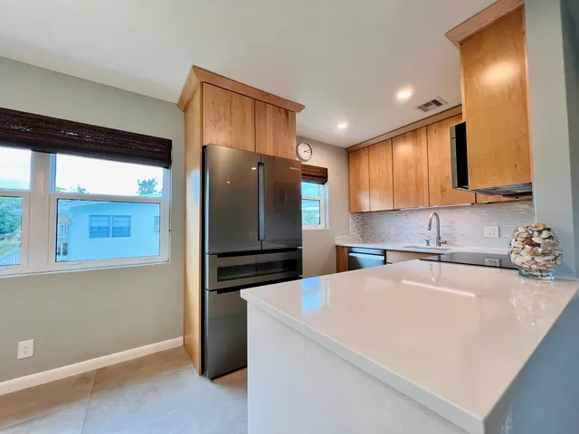 a kitchen with a refrigerator sink and cabinets