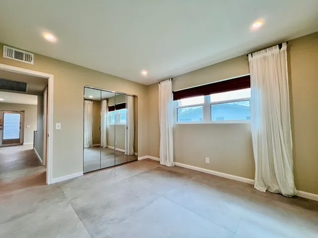 an empty room with sliding door and wooden floor