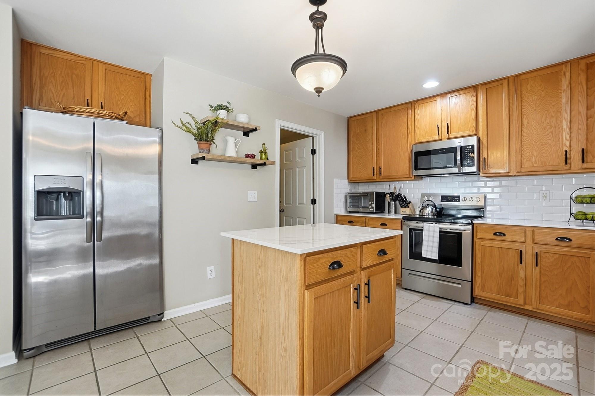 7200 Cascading Pines Drive Tega Cay, SC 29708 - Photo 14 of 39 a kitchen with stainless steel appliances granite countertop a refrigerator a stove a sink and a microwave