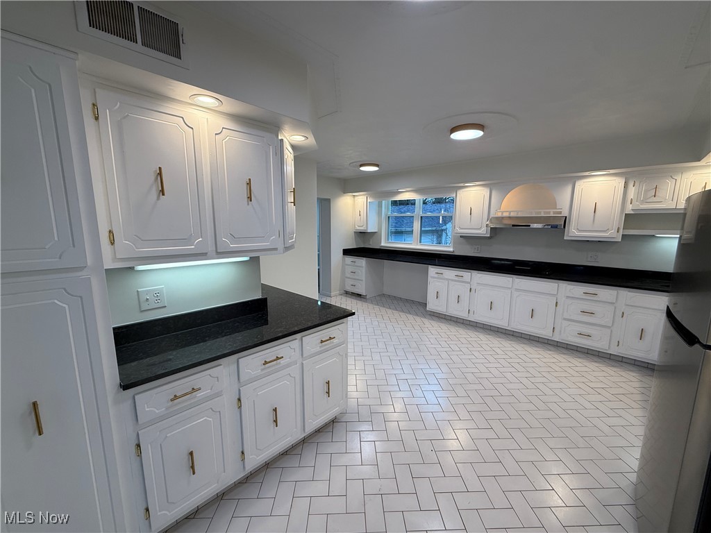 522 North 3rd Street Toronto, OH 43964 - Photo 10 of 47 Kitchen featuring white cabinetry, freestanding refrigerator, dark stone countertops, black cooktop, and under cabinet range hood