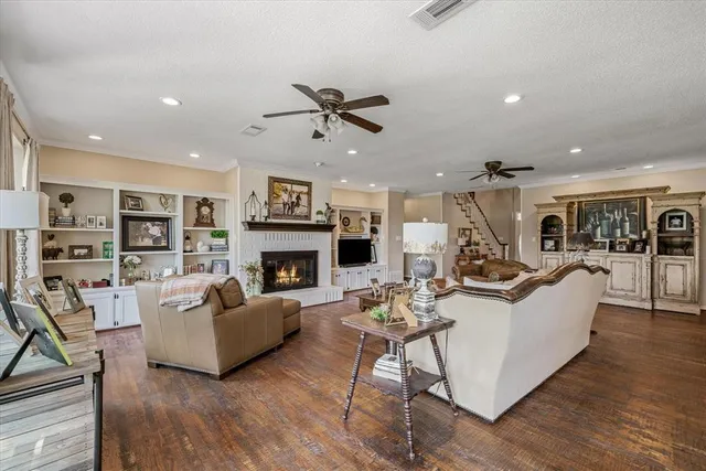 a living room with fireplace furniture and a wooden floor