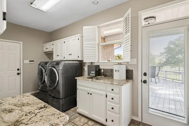 a utility room with cabinets washer and dryer