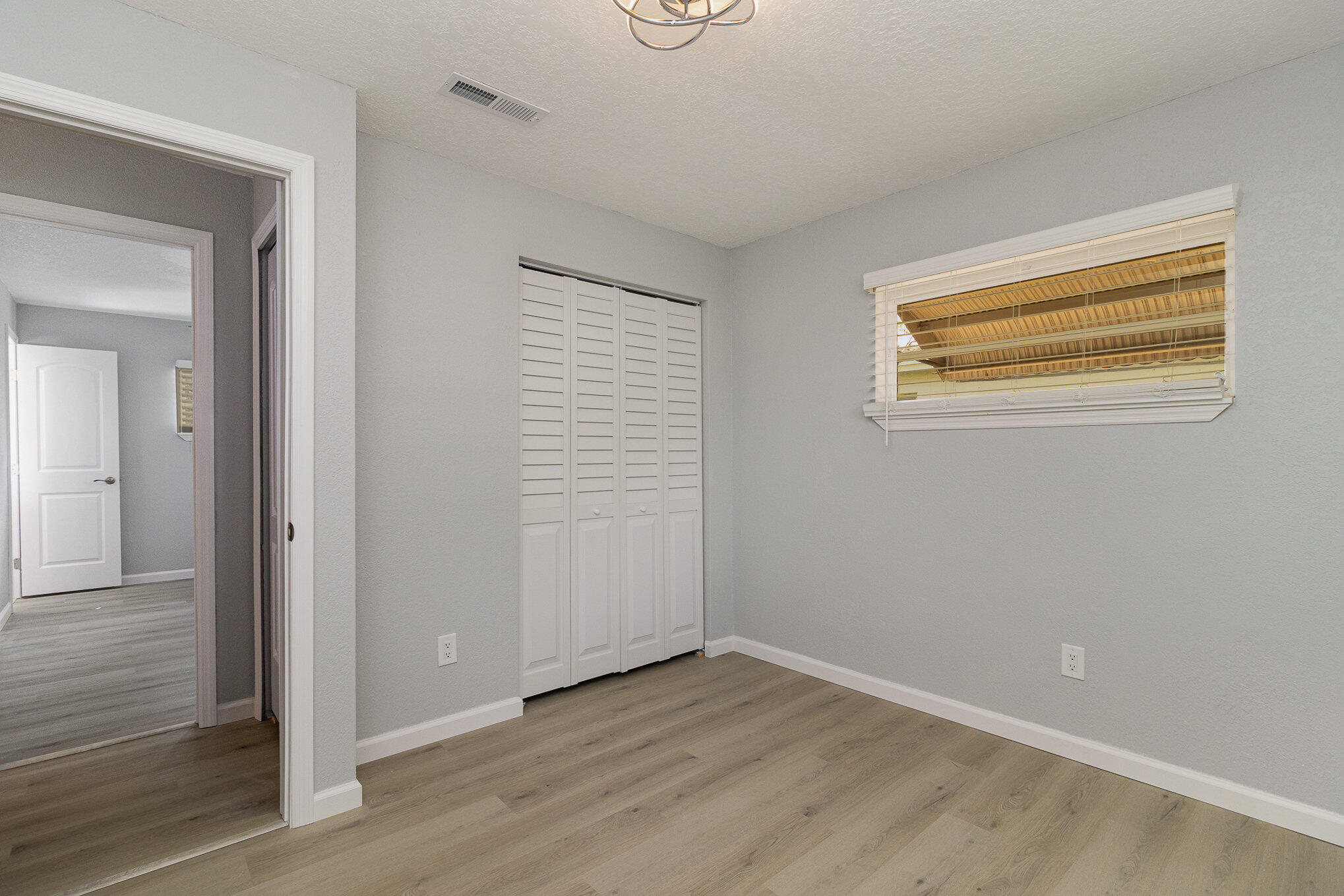 937 Kings Post Road Rockledge, FL 32955 - Photo 18 of 24 a view of an empty room with wooden floor and a window