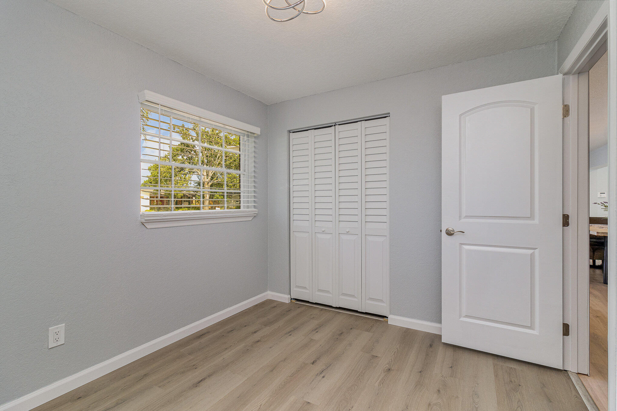 937 Kings Post Road Rockledge, FL 32955 - Photo 19 of 24 an empty room with wooden floor and windows