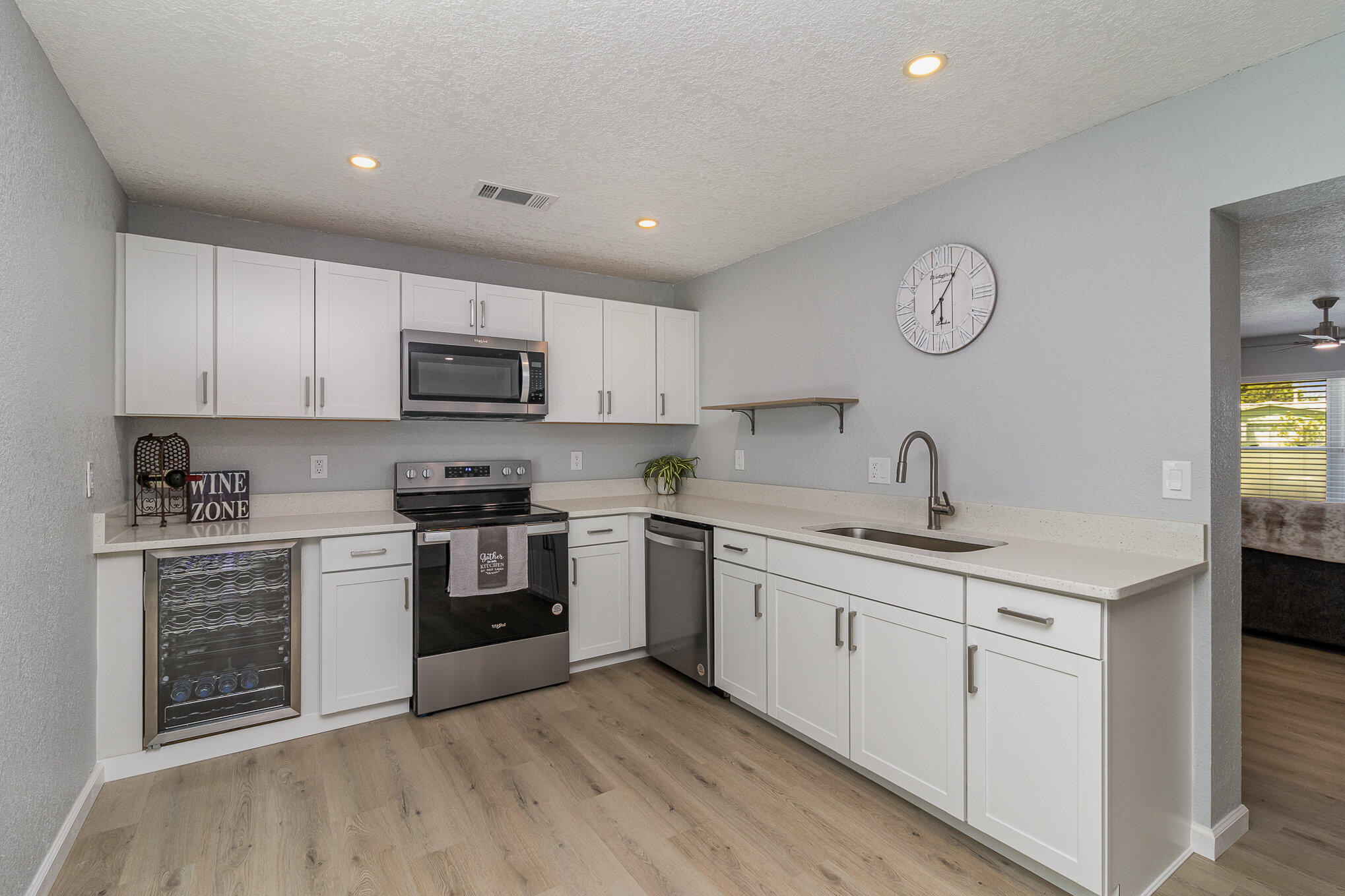 937 Kings Post Road Rockledge, FL 32955 - Photo 4 of 24 a kitchen with granite countertop white cabinets and stainless steel appliances