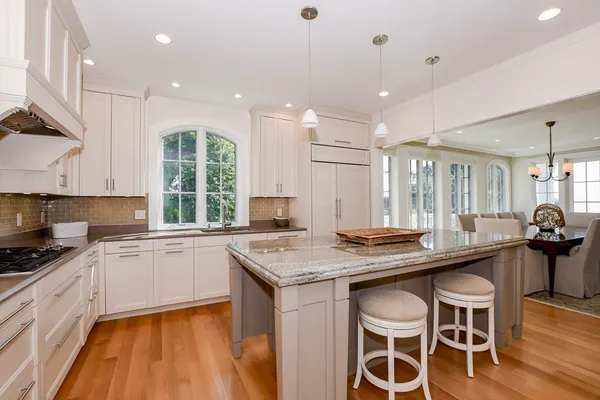 a kitchen with stainless steel appliances granite countertop a stove a sink a microwave a center island and furniture