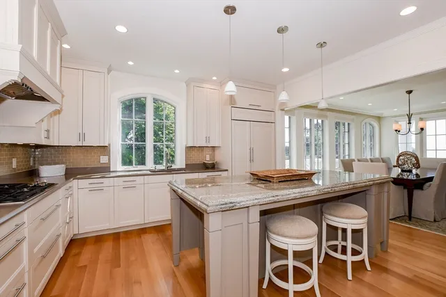 a kitchen with stainless steel appliances granite countertop a stove a sink a microwave a center island and furniture