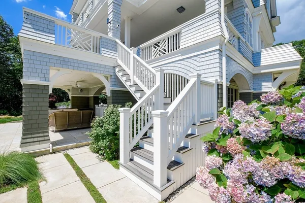 a view of a house with entrance stairs and potted plants