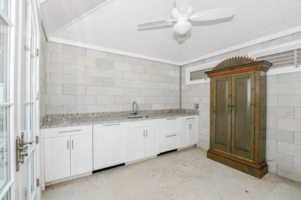 a bathroom with a granite countertop sink a toilet and shower