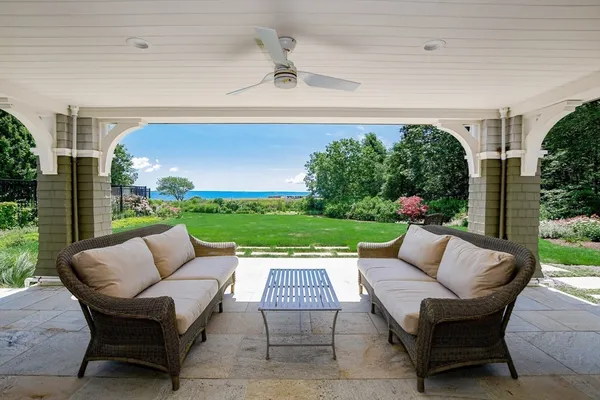a view of a patio with couches table and chairs with plants and trees