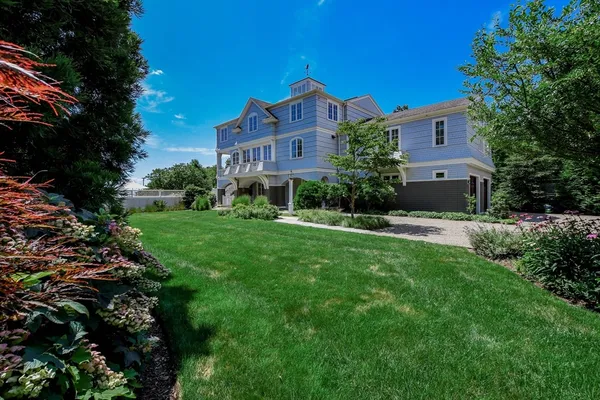 a front view of a house with yard and green space