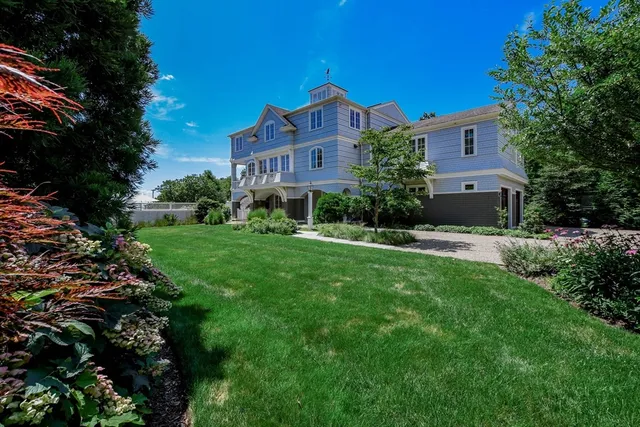 a front view of a house with yard and green space