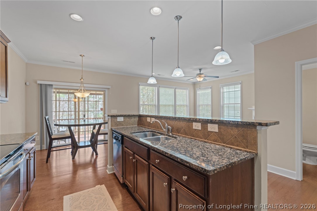 126 Pine Hawk Drive Spring Lake, NC 28390 - Photo 4 of 48 an open kitchen with granite countertop stove a sink a dining table and chairs