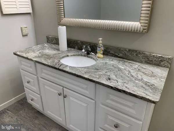 a bathroom with a granite countertop sink and a mirror