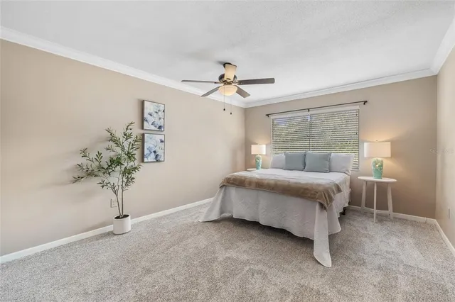 a bedroom with a bed and a ceiling fan