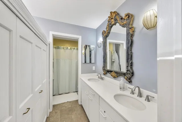 a en suite bathroom with a sink double vanity and a mirror