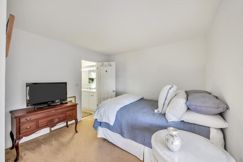 4 Bob White Crescent, Unit 4 Mashpee, MA 02649 - Photo 28 of 37 a bedroom with a bed and a flat screen tv