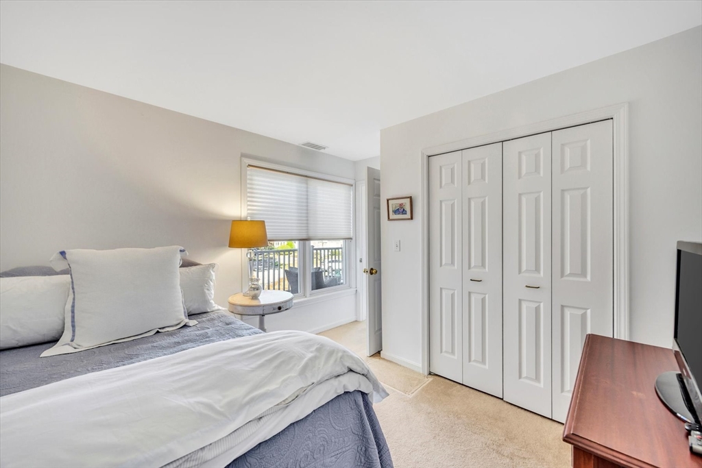 4 Bob White Crescent, Unit 4 Mashpee, MA 02649 - Photo 29 of 37 a bedroom with a bed and wooden floor