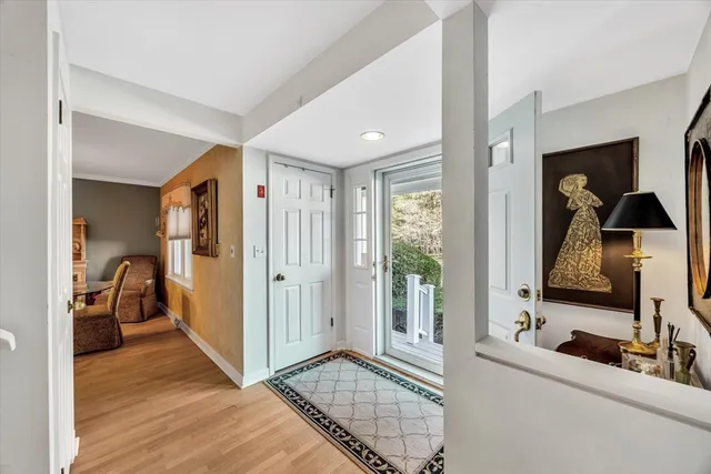 a view of a hallway with wooden floor and windows