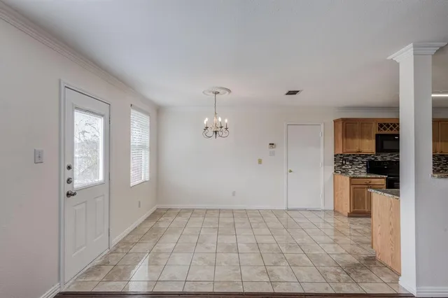 an empty room with wooden floor fireplace and windows