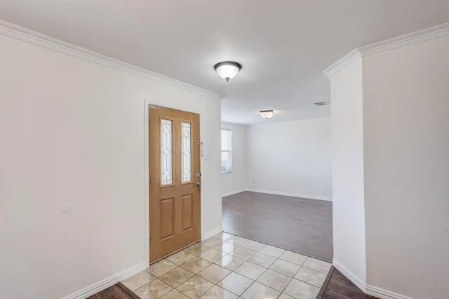 an empty room with wooden floor and mirror
