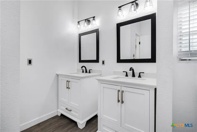 a bathroom with 2 sink and a mirror