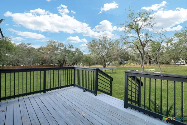 a view of balcony with wooden floor and fence