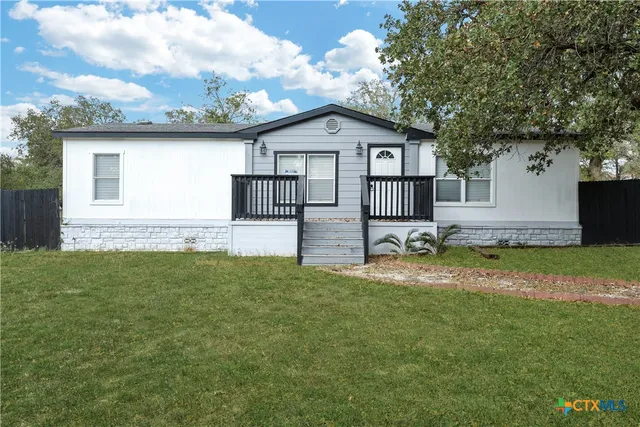 a backyard of a house with table and chairs