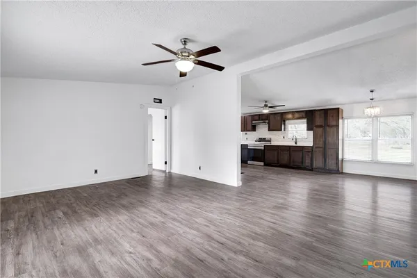 a view of empty room with wooden floor and window