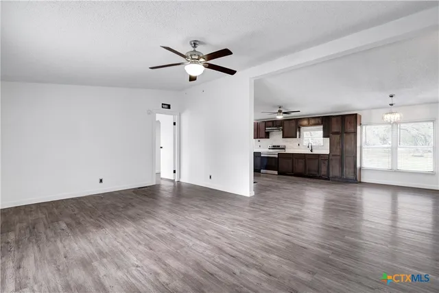 a view of empty room with wooden floor and window