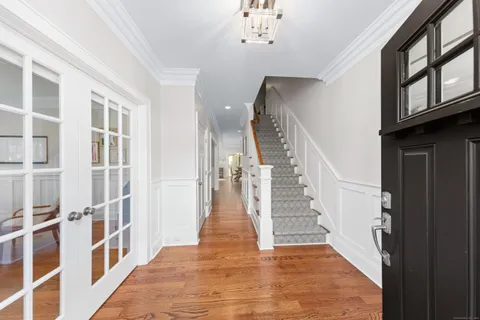 a view of staircase with lots of frames on wall and wooden floor