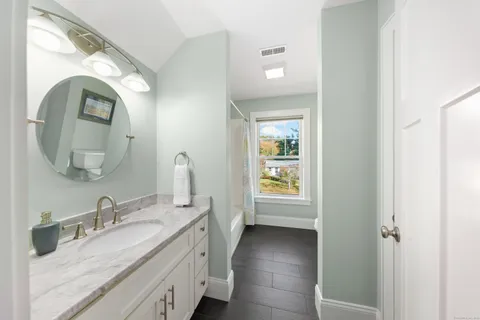 a en suite bathroom with a granite countertop double vanity sink and a mirror