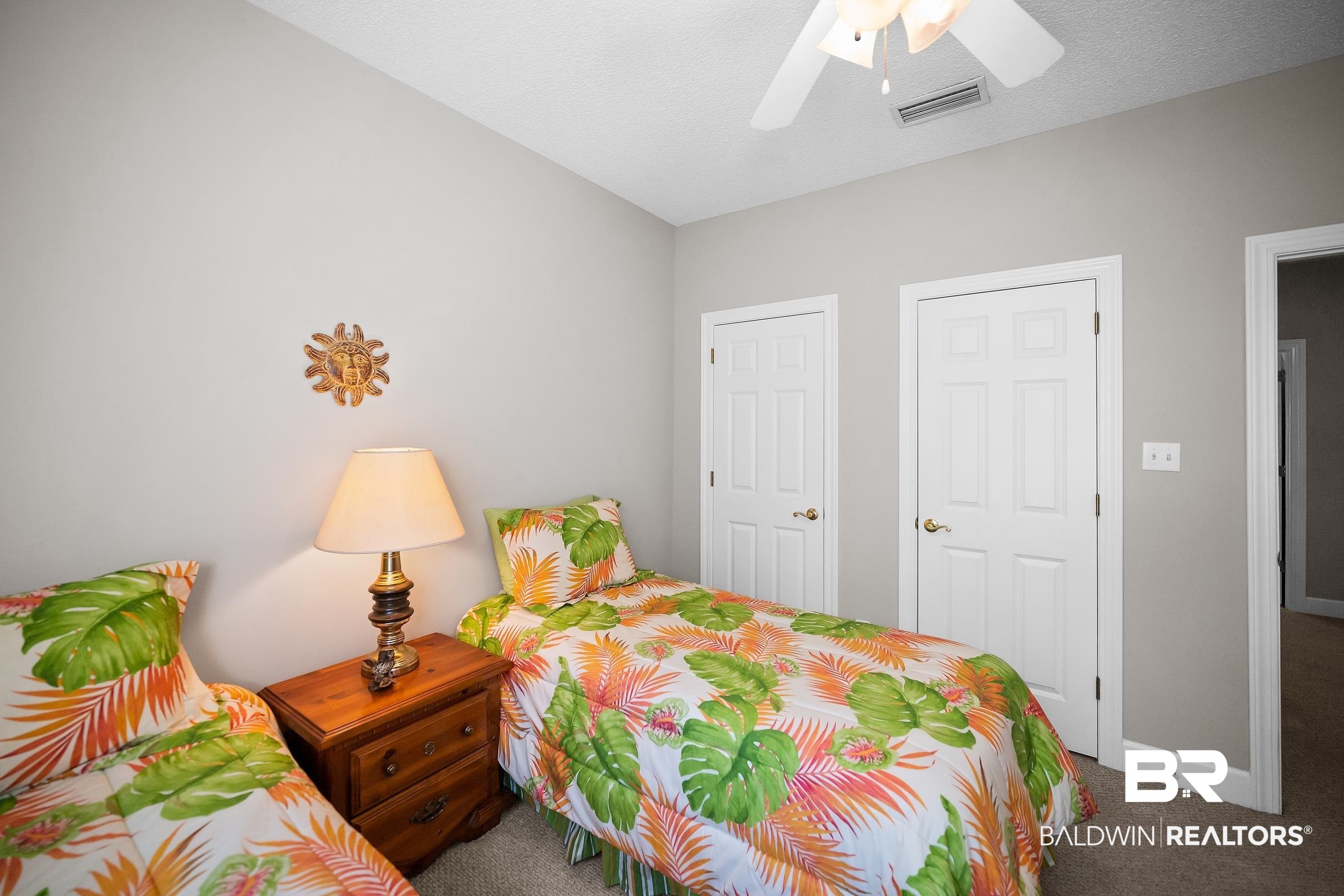430 West Fort Morgan Road, Unit 704 Gulf Shores, AL 36542 - Photo 24 of 35 Bedroom featuring neutral wall paint, two white paneled doors, and a ceiling fan with integrated lighting