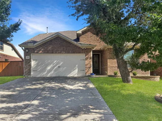 a front view of a house with a garden and yard
