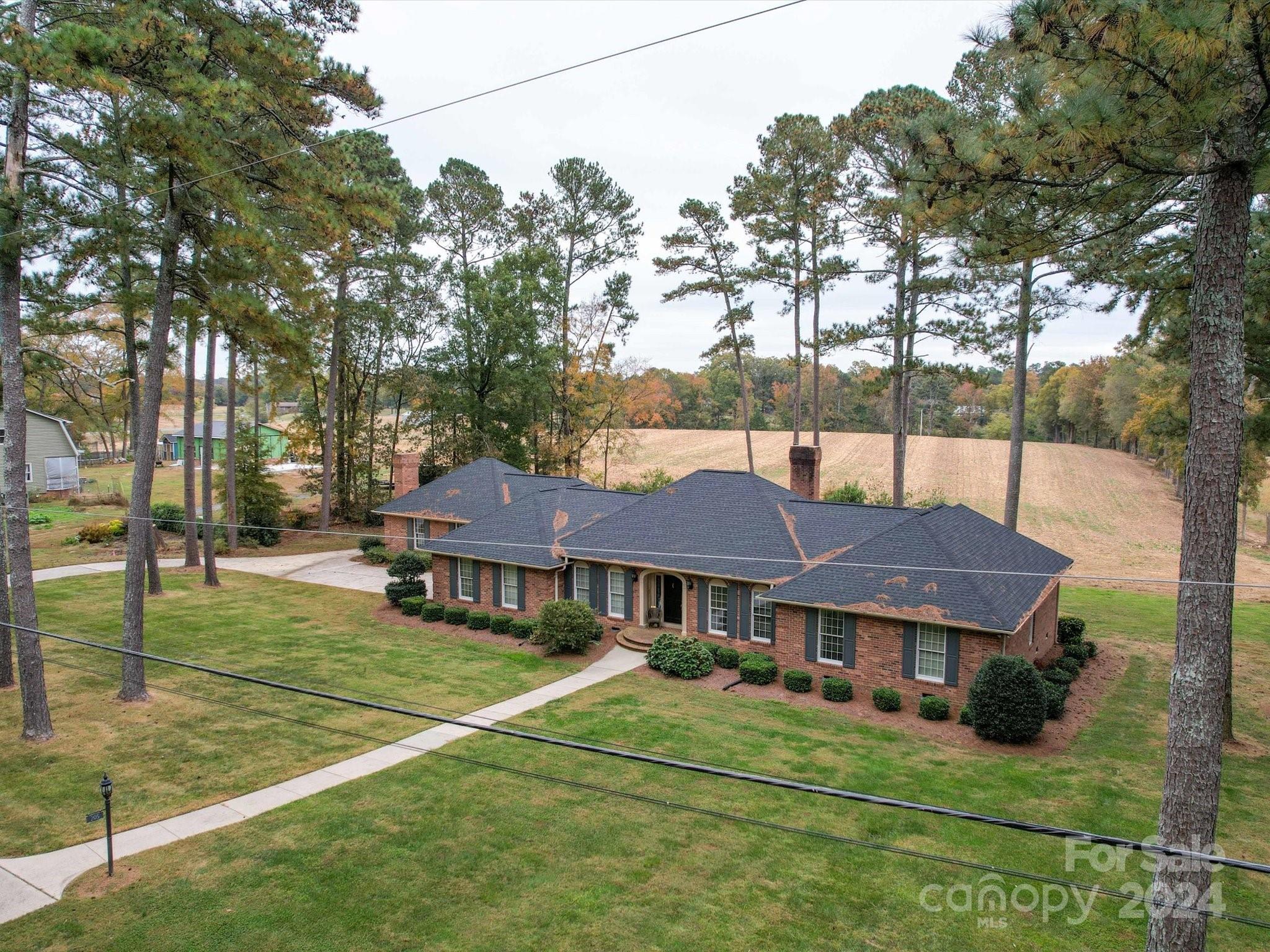 205 James Road Oakboro, NC 28129 - Photo 3 of 48 a view of a big house with a big yard and large trees