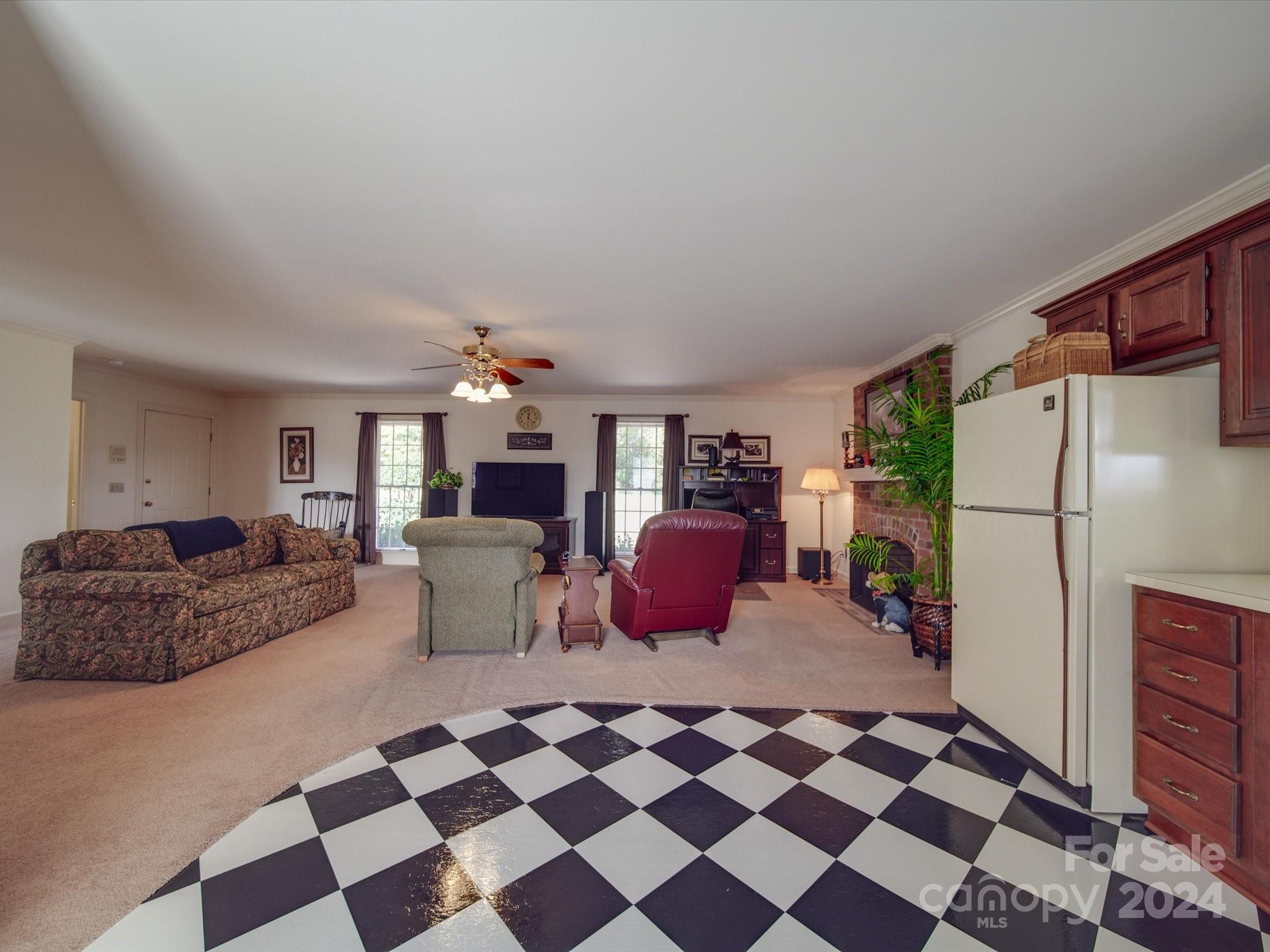 205 James Road Oakboro, NC 28129 - Photo 36 of 48 a living room with a black white checkered floor with a gaming machine and dining chairs