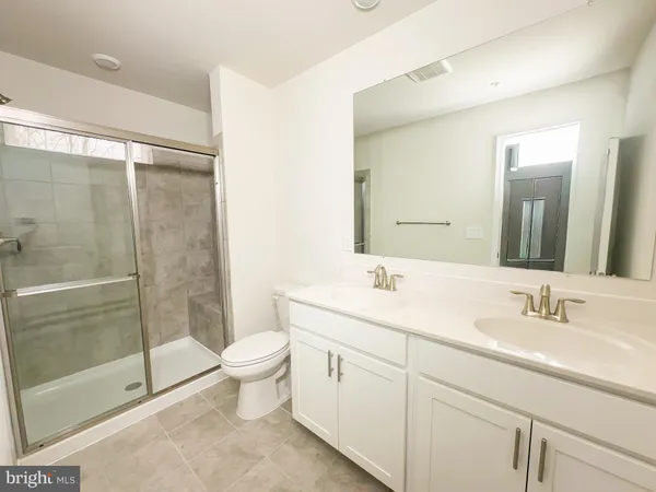 a bathroom with a double vanity sink toilet and shower