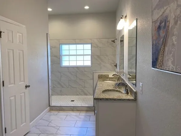 a bathroom with a sink a shower and a mirror