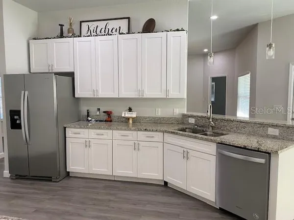 a kitchen with stainless steel appliances granite countertop a refrigerator sink and cabinets