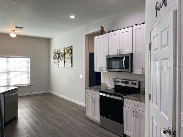 9050 Northeast 80th Street Bronson, FL 32621 - Photo 6 of 12 a kitchen with a stove and a microwave