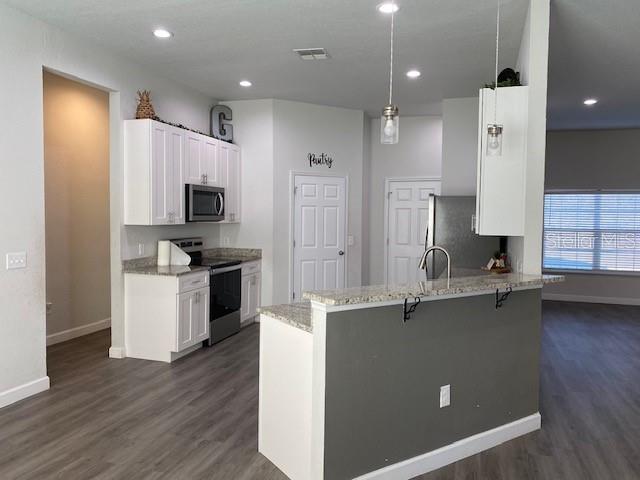 9050 Northeast 80th Street Bronson, FL 32621 - Photo 8 of 12 a kitchen with kitchen island white cabinets and refrigerator