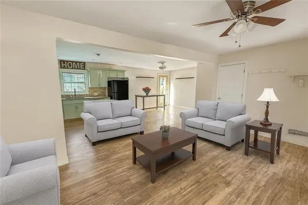 a living room with furniture and a wooden floor
