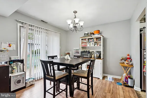 a view of a dining room with furniture a chandelier and wooden floor