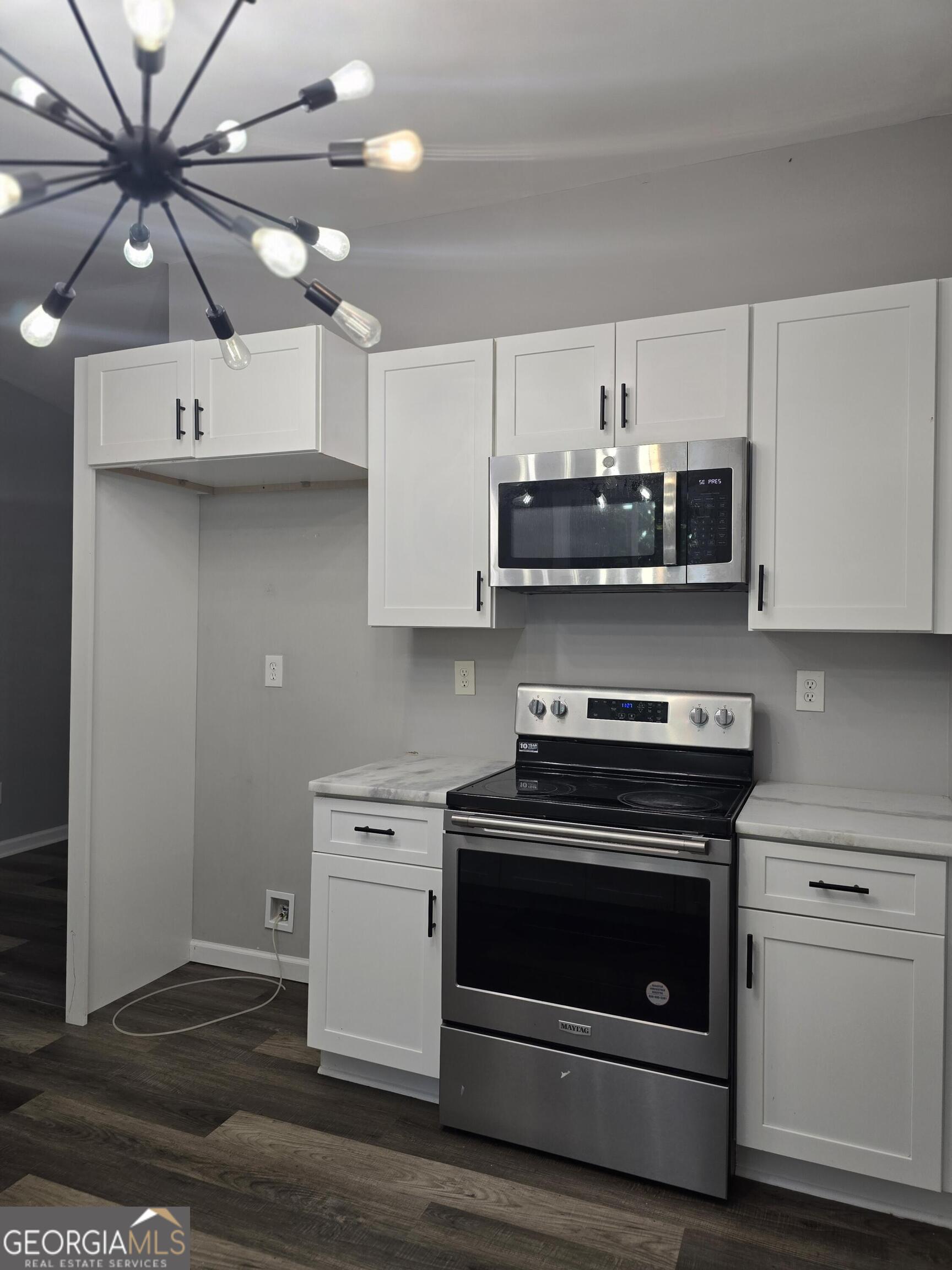 1109 Liberty Church Road Bremen, GA 30110 - Photo 25 of 26 a kitchen with stainless steel appliances a stove a microwave and white cabinets