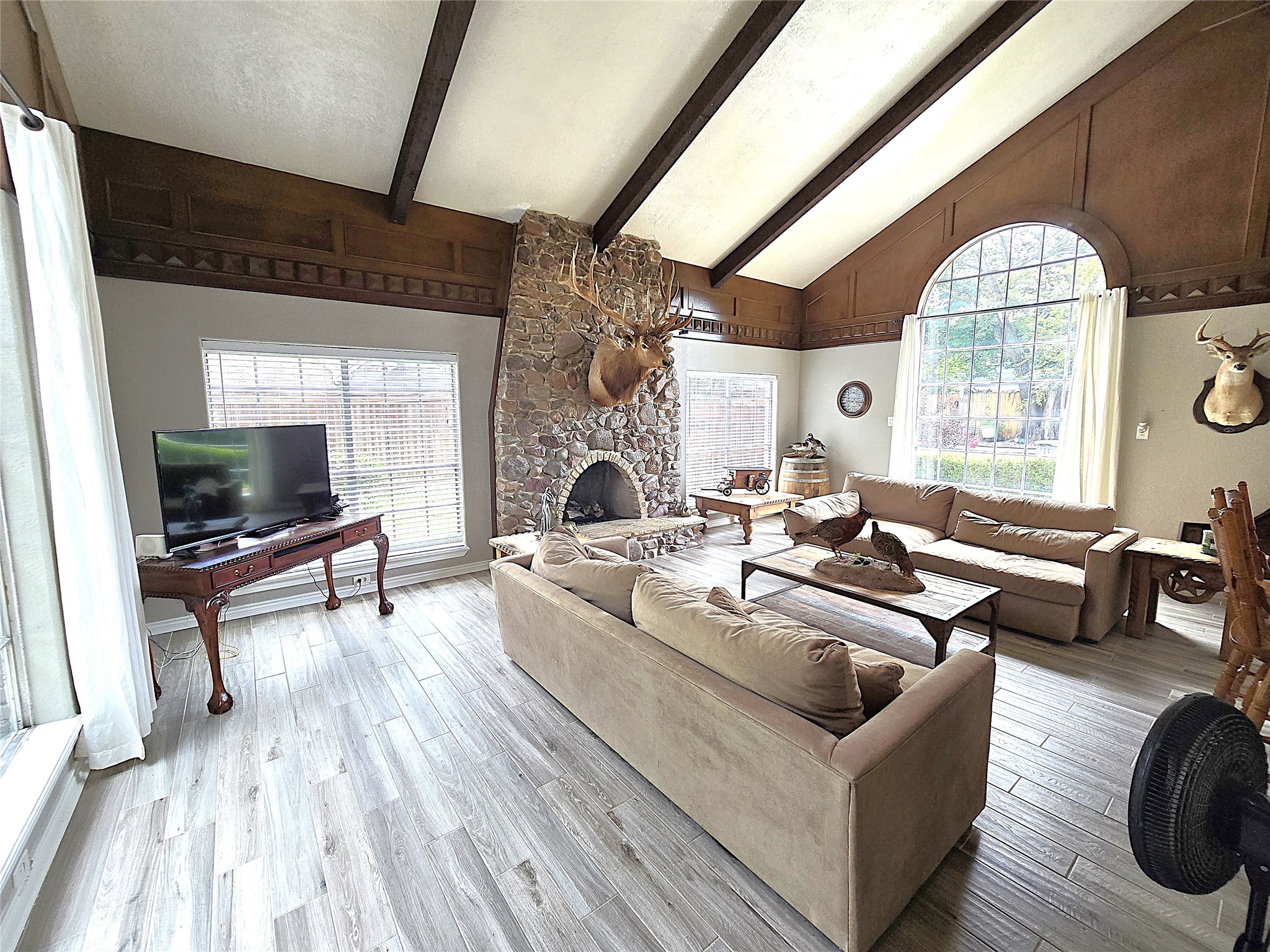 560 Brandon Road Conroe, TX 77302 - Photo 31 of 45 Step into a welcoming living room with high ceilings, a cozy stone fireplace, and abundant natural light, offering a perfect blend of comfort and style.