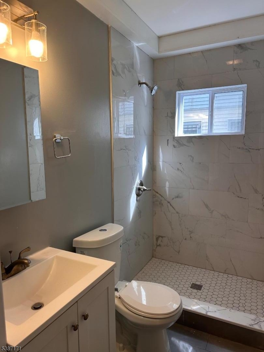 87 Lyons Avenue Newark, NJ 07112 - Photo 12 of 13 a bathroom with a sink a toilet and shower