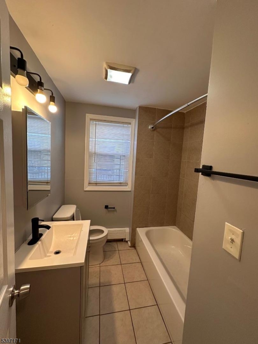 87 Lyons Avenue Newark, NJ 07112 - Photo 13 of 13 a bathroom with a sink a toilet and mirror