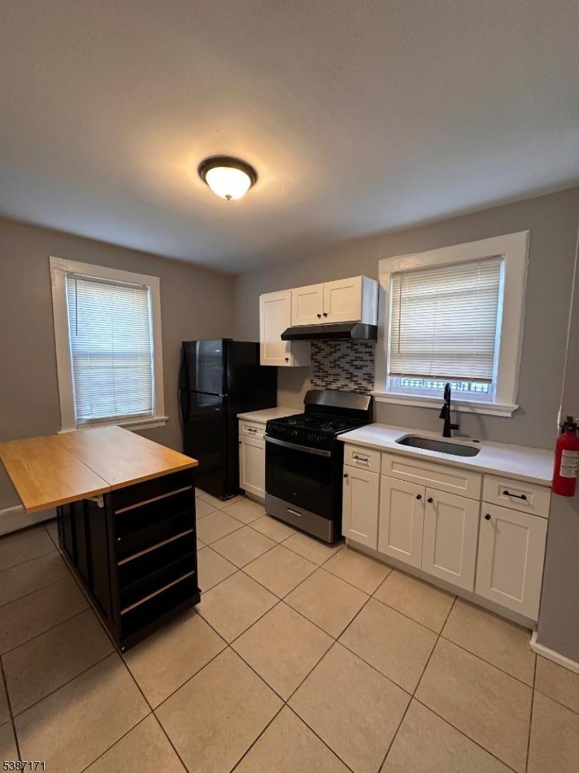 87 Lyons Avenue Newark, NJ 07112 - Photo 4 of 13 a kitchen with a stove a sink and a microwave